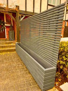 a grey bench sitting on top of a brick walkway