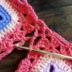 the crocheted scarf is being worked on with a pair of knitting scissors next to it