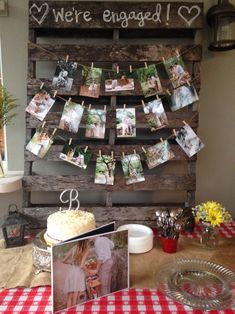 a table topped with a cake next to a wooden sign that says we're engaged