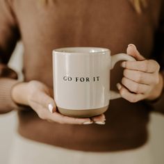 a woman holding a coffee mug with the words go for it written on it in black