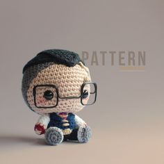 a crocheted doll with glasses and a sweater