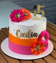 a colorful cake with flowers on top sitting on a table