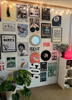 a room with posters and plants on the wall