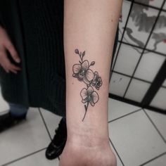 a small flower tattoo on the wrist