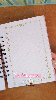 a hand holding a notebook with dots on it