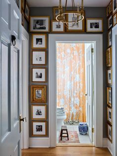 an entry way with pictures on the wall and framed photos on the walls above it