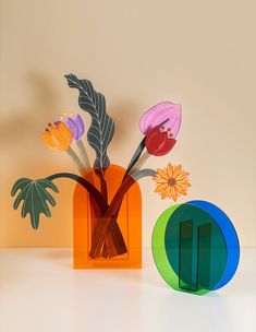 three different colored vases with flowers in them