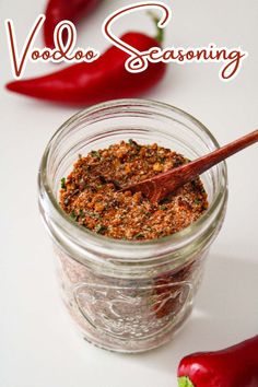 a jar filled with seasoning next to red peppers