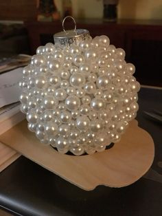 a white beaded ornament sitting on top of a wooden tray