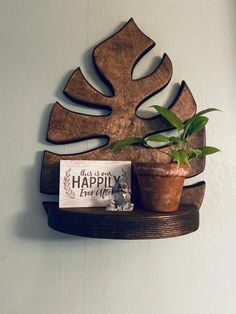 a potted plant sitting on top of a wooden shelf next to a sign that says happy earth