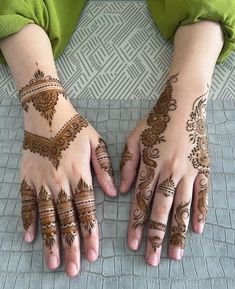 two hands with henna tattoos on them