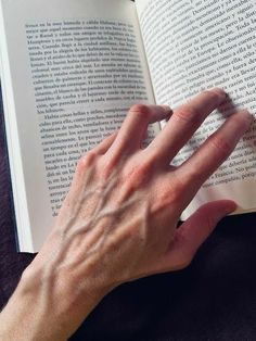 a person's hand on top of an open book