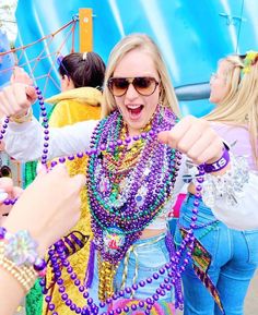 a woman in sunglasses and beads is pointing at something