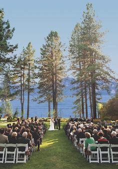 a wedding ceremony in the middle of a pine forest with an ocean view behind it