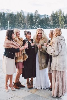 a group of women standing next to each other in front of a body of water