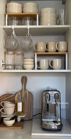 the shelves are filled with dishes, cups, and mixers for cooking or baking