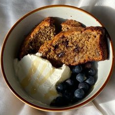 a bowl filled with blueberries, bread and ice cream