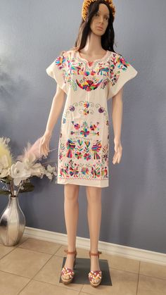 This Beautiful Mexican Colorful Floral Dress is the perfect dress for a fun night out or a special event. -It is full of colorful embroidered flowers and Tenango embroidered -This dress has ties on the back in order to adjust the fit. Hand embroidered. 100% artisanal Made in Mexico al ser bordado a mano.. todos los bordados son diferentes. Folk Style Multicolor Dress For Fiesta, Multicolor Folk Style Dress For Fiesta, Multicolor Folk Dress For Fiesta, Multicolor Embroidered Dress For Cinco De Mayo Fiesta, Multicolor Embroidered Dress For Cinco De Mayo, Multicolor Short Sleeve Embroidered Dress For Cinco De Mayo, Multicolor Cotton Dress For Cinco De Mayo, Embroidered Multicolor Dress For Cinco De Mayo, Multicolor Embroidered Dress For Cinco De Mayo Festival