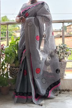 This exquisite handloom saree exudes a sense of understated elegance and contemporary charm. Crafted from pure, lightweight cotton, it presents a harmonious blend of colors and intricate detailing, making it a versatile choice for various occasions, particularly ideal for the upcoming festive season. The dominant shade of this saree is a steel grey, reminiscent of sophistication and modernity. The body of the saree is adorned with delicate zari checks, which glisten with a subtle opulence. What sets this saree apart is its captivating patchwork design, featuring different distinct handblock-printed pure cotton fabrics in rich black, and complementary steel grey, harmonizing with the saree's base color and vibrant pink, infusing a pop of color and vivacity into the ensemble. the saree is th Cotton Saree Blouse Piece With Weaving Work, Cotton Handloom Pre-draped Saree For Festive Occasion, Cotton Pre-draped Saree With Printed Border For Festivals, Festive Cotton Handloom Pre-draped Saree, Festive Pre-draped Cotton Saree With Printed Border, Handloom Cotton Saree Blouse Piece, Cotton Block Print Saree For Festivals, Cotton Blouse Piece With Printed Border, Cotton Pre-draped Saree With Printed Border