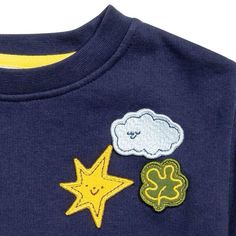 a blue shirt with yellow stars and clouds on the front, two green clovers in the back