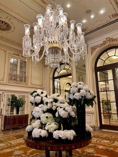 a chandelier hanging from the ceiling in a large room with flowers on it