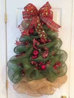 a christmas tree made out of mesh with red and green decorations on it's front door