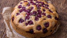 a cake with cherries on it sitting on top of a piece of wax paper