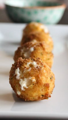 three fried food items on a plate with sauce and parmesan cheese in the middle