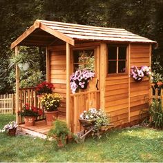 a small wooden shed with flowers in it