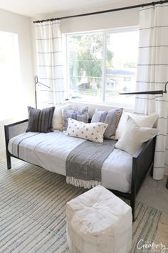 a living room with a couch, ottoman and window