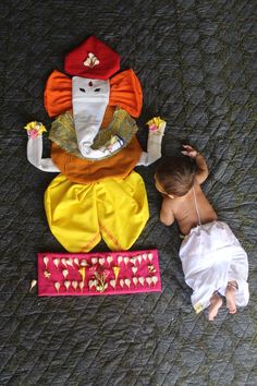 a small child laying on top of a bed next to a stuffed animal