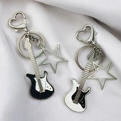 two key chains with guitars on them are laying next to each other in the shape of stars