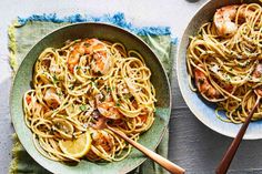 two bowls filled with shrimp and pasta on top of a table