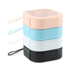 four different colored containers are stacked on top of each other and one has a cord attached to it