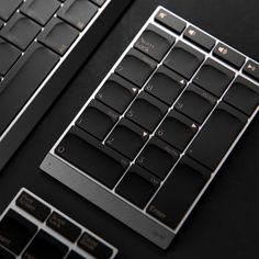 two black keyboards sitting next to each other on a table