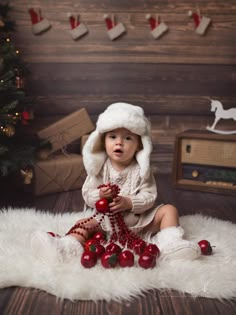 a baby wearing a santa hat sitting on the floor