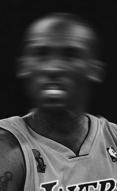 a black and white photo of a basketball player wearing a jersey with the word lakers on it