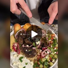 a person cutting up food on top of a white plate with vegetables and meats