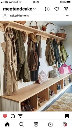 a bunch of coats hanging on a wall next to a shelf with shoes and purses