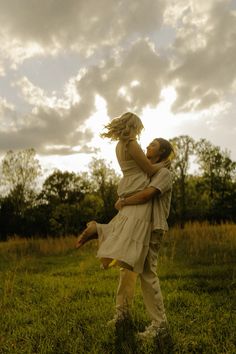 a man and woman are hugging in the grass