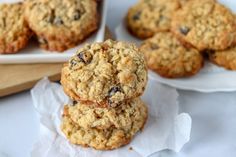 three oatmeal cookies stacked on top of each other in front of two white plates