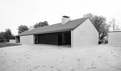 a black and white photo of a brick building with two garages on the side