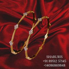 a pair of gold bracelets with diamonds on red velvet background, for sale at shauri's fine jewelry