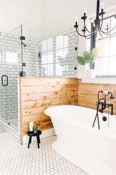 a white bath tub sitting in a bathroom next to a walk in shower