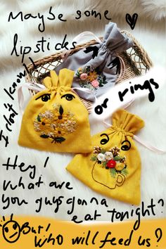 two bags with embroidered faces on them sitting on a white furnishce covered floor