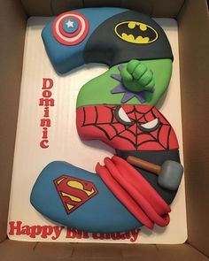 a birthday cake in the shape of a number 3 with a batman and spiderman theme