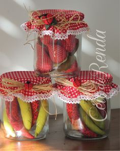 four jars filled with pickles and strawberries