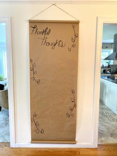 a brown paper bag with writing on it hanging from the wall in front of a kitchen