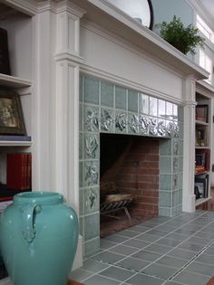 a fireplace in a living room next to a book shelf with books on top of it