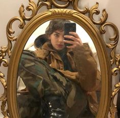 a young man taking a selfie in front of a mirror